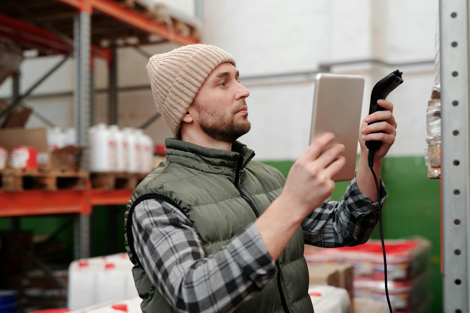 Warehouse operator scanning RFID-tagged stock with a handheld reader — SAP EWM goods receipt and handling-unit management.