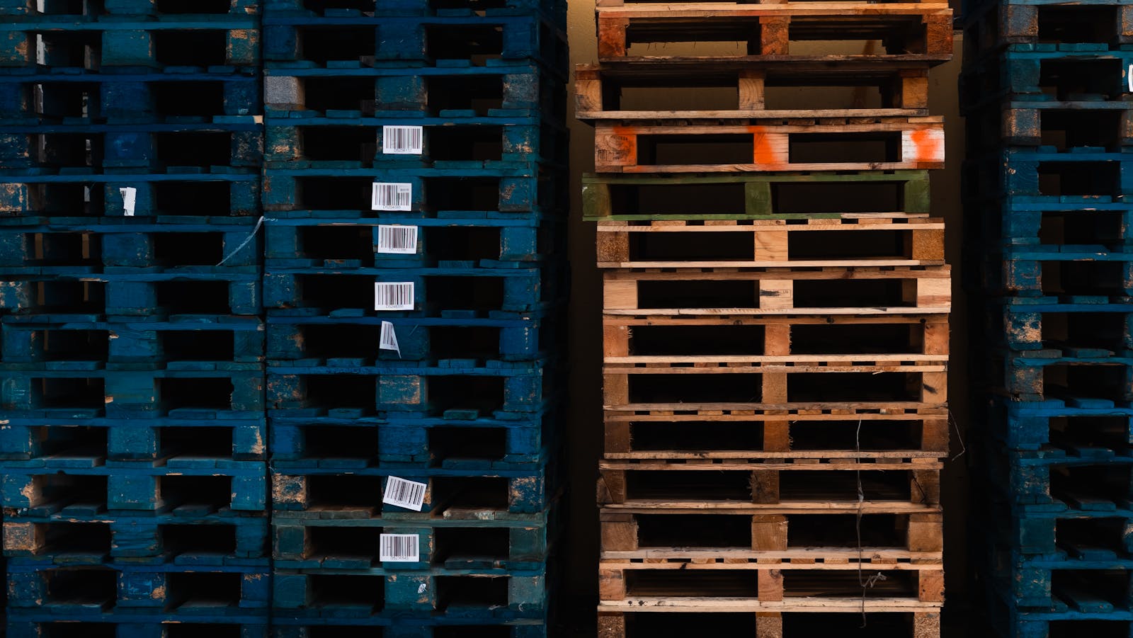 Barcoded shipping pallets stacked in a distribution center — RFID inventory tracked through NetSuite ERP.