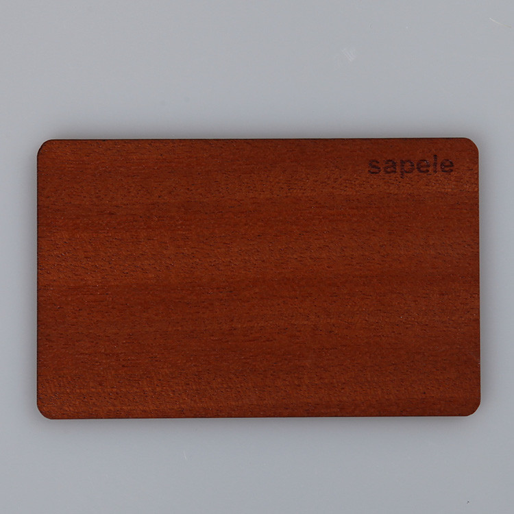 Single sapele wood RFID card with engraved lettering on a gray background